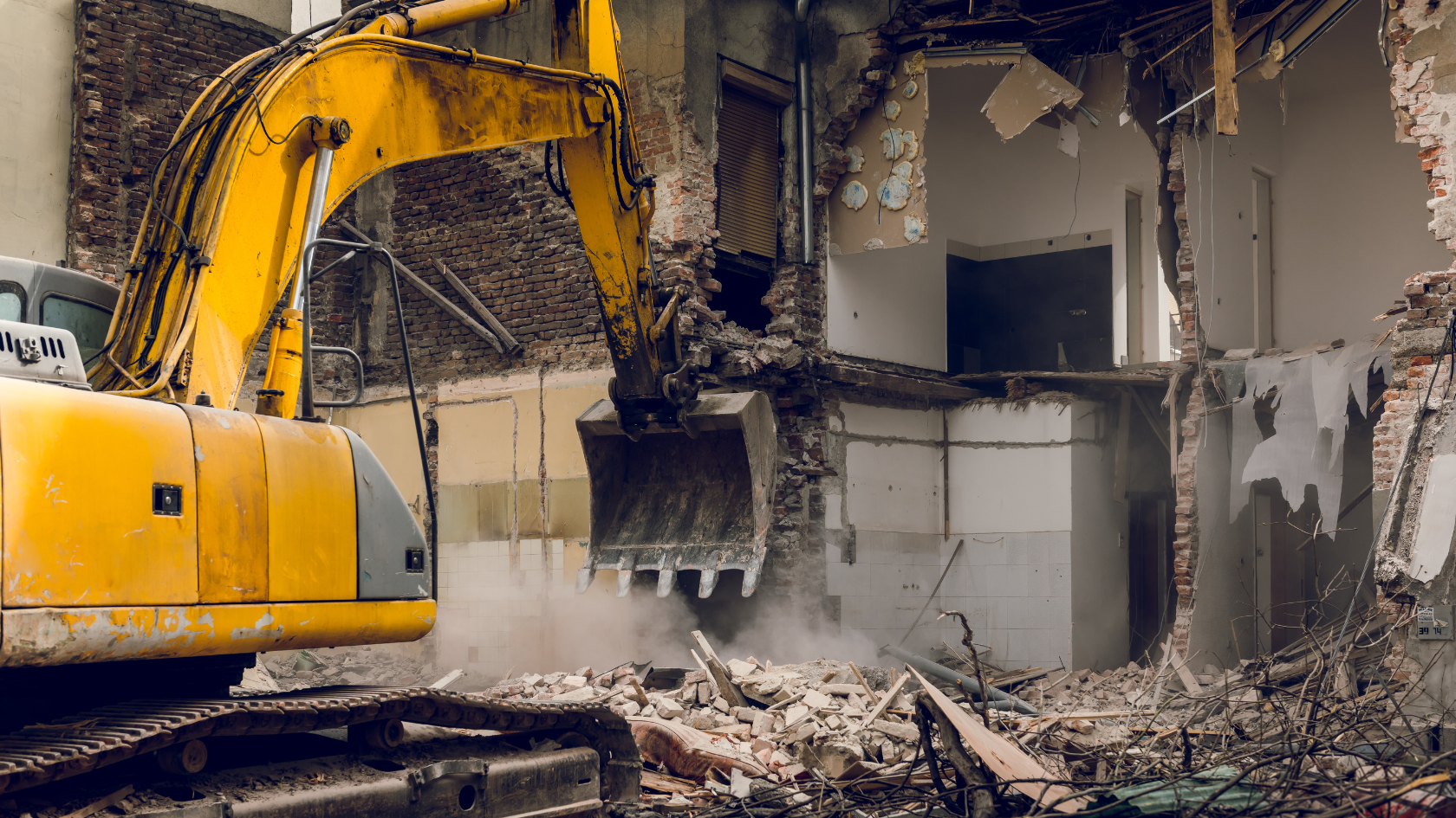 A bulldozer digging through a demolished building