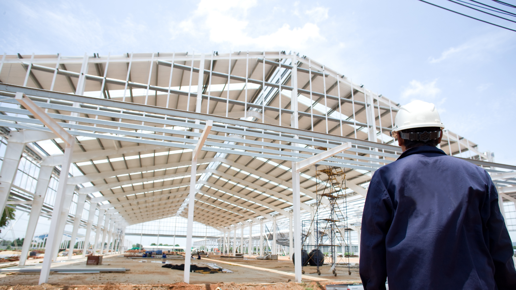 A man standing in front of a building under construction